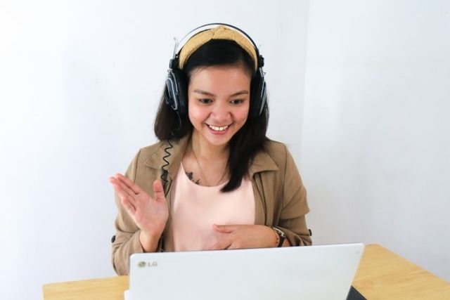 Woman Speaking to Laptop Webcam