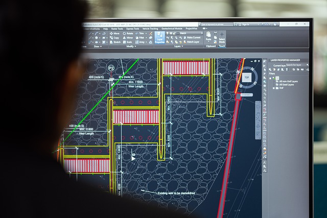 Engineer with Schematic Displayed on Computer