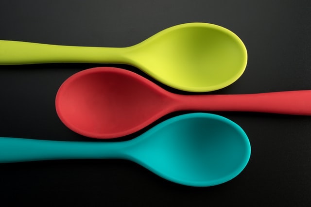 Three Colourful Mixing Spoons on Black Background