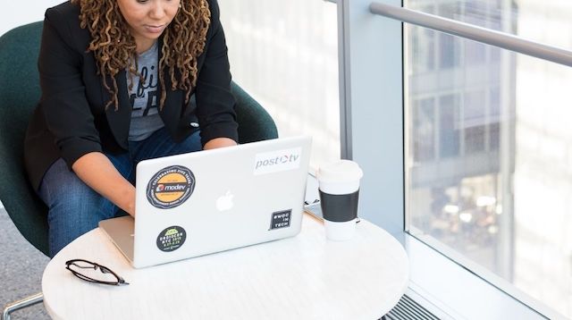 Woman Working on Laptop Next to Window