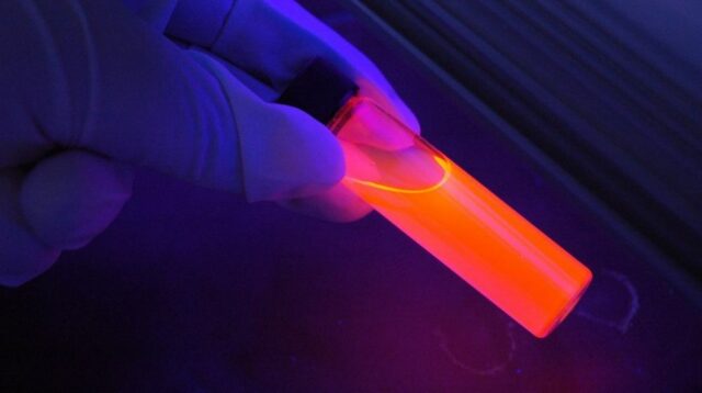 R&D Scientist Holding a Fluorescent Vial