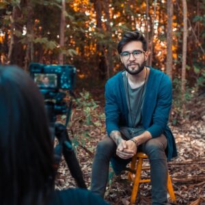 Man Seated Outside Talking on Camera