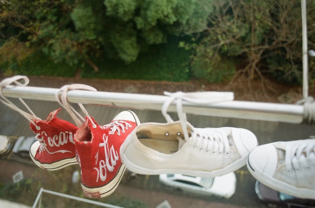 Two pairs of shoes hanging in a shop window