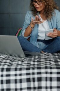 Woman Sitting on Bed Talking to Someone Online