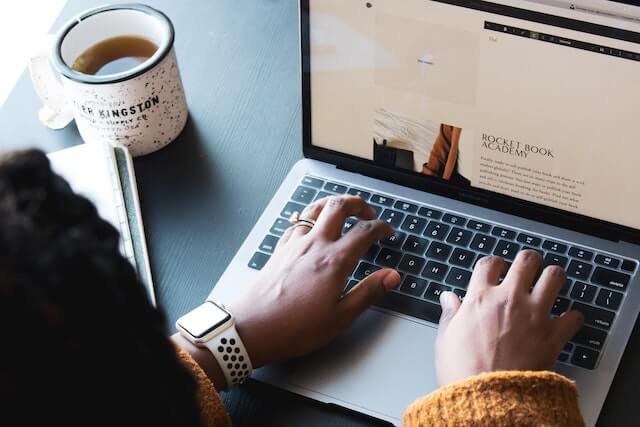 Close-up of person typing on laptop