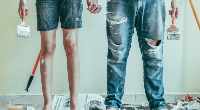 Couple with paintbrushes holding hands