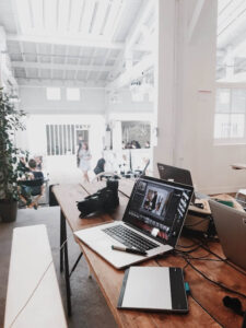 Laptop on desk with camera and other content production equipment