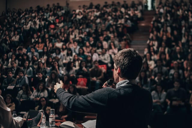 Man giving speech to auditorium full of people