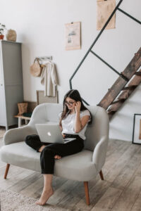 Woman smiling at laptop while sitting in living room