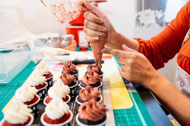 Baker decorating cupcakes with icing