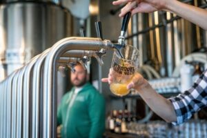 Business Structure Woman Filling Beer Mug from Tap