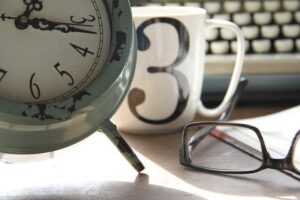 Clock, mug and glasses on a desk