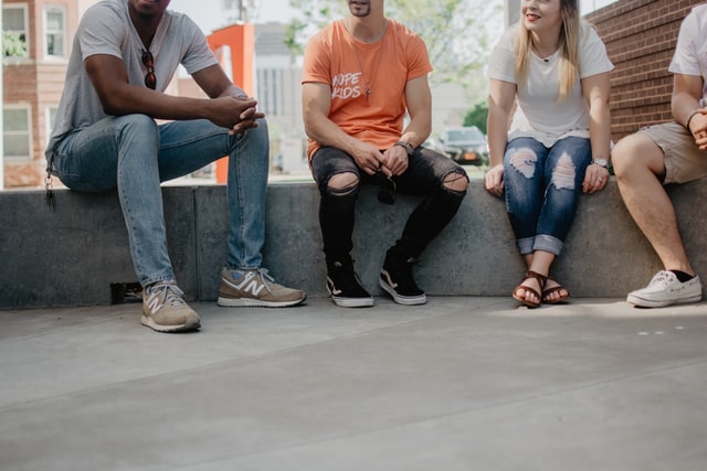 Four people sitting outside talking