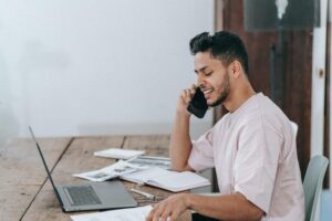 Man With Laptop Talking on Phone