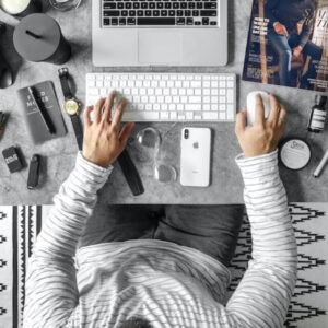 Overhead view of person at desk working on laptop