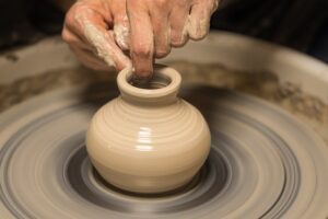 Person creating a vase on a potter's wheel