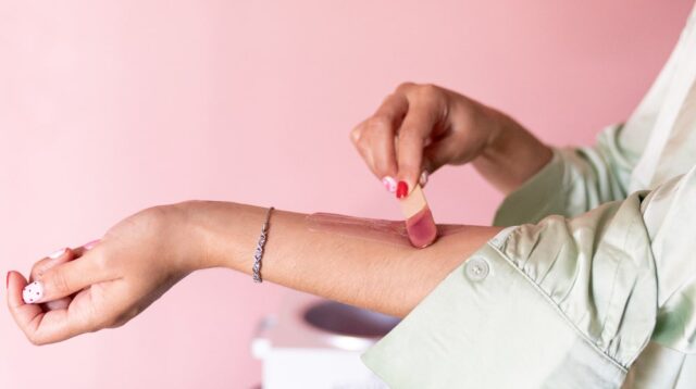 Woman spreading pink gel on her arm