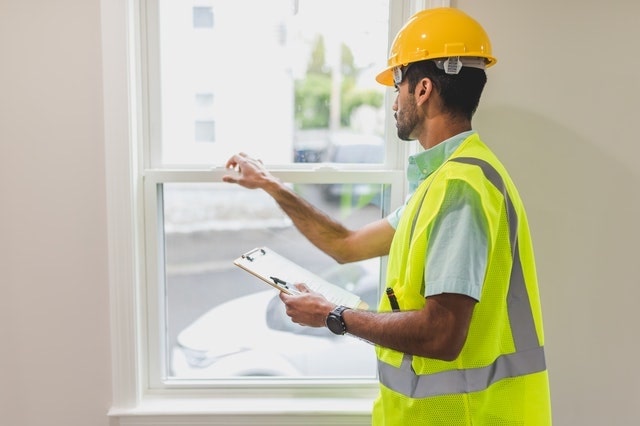Worker in a hard hat checking a window