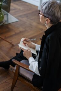 Gray Haired Woman Holding Notebook and Pen