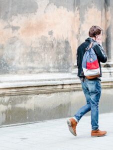 Man Walking Outside While Talking on Phone