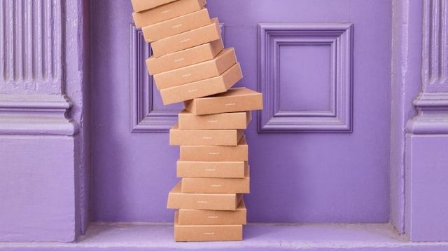 Tall Stack of Boxes Piled Up Outside Purple Door