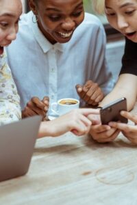 Three Women Reacting to Something on a Smartphone