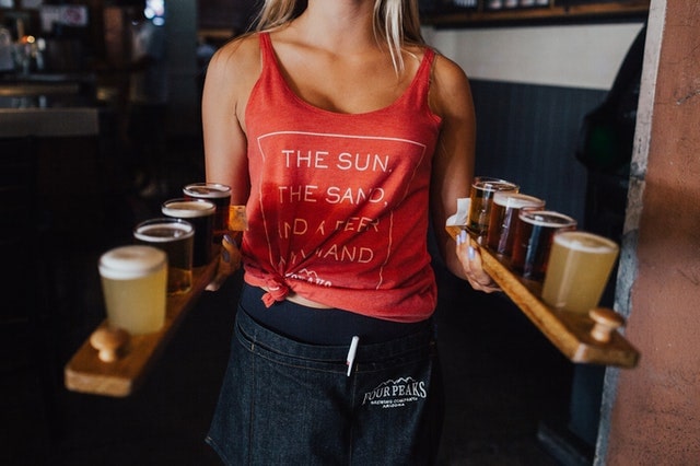 Waitress Holding Two Flights of Beer Samples