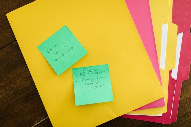 Bright colored folders fanned out on table with sticky notes