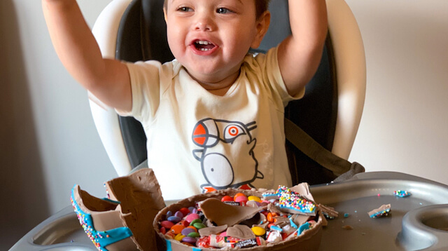 Stephanie's two year-old son enjoying pinata cake in highchair