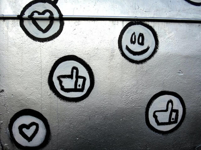 Social media symbols for likes and dislikes painted on silver wall