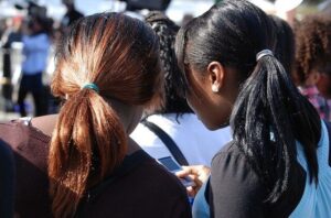 Two women with their heads together talking