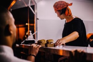 Food truck worker serving burgers