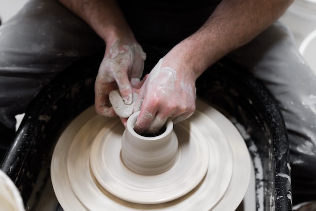 Man throwing a clay pot on a wheel