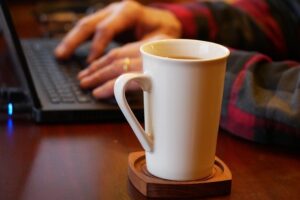 man working on a laptop with a mug of coffee