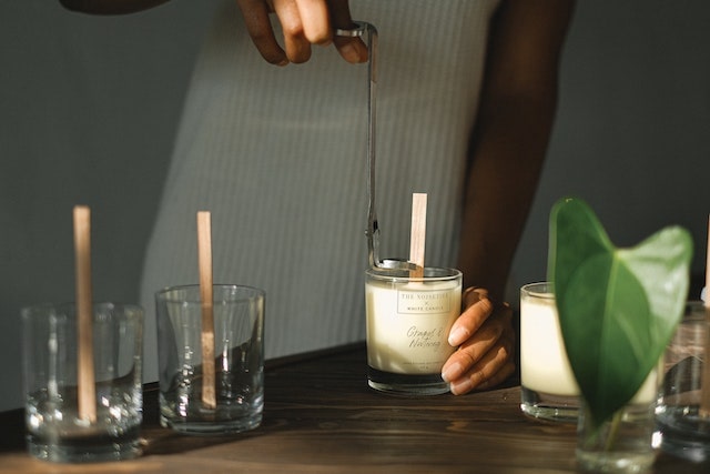 Person trimming the wick on a candle