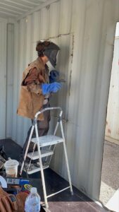 Photo of John’s son at work on a container home