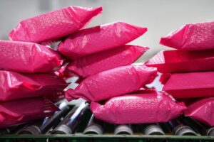 Pink-wrapped parcels on a conveyer belt