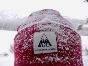 Red YNA hat covered in snow