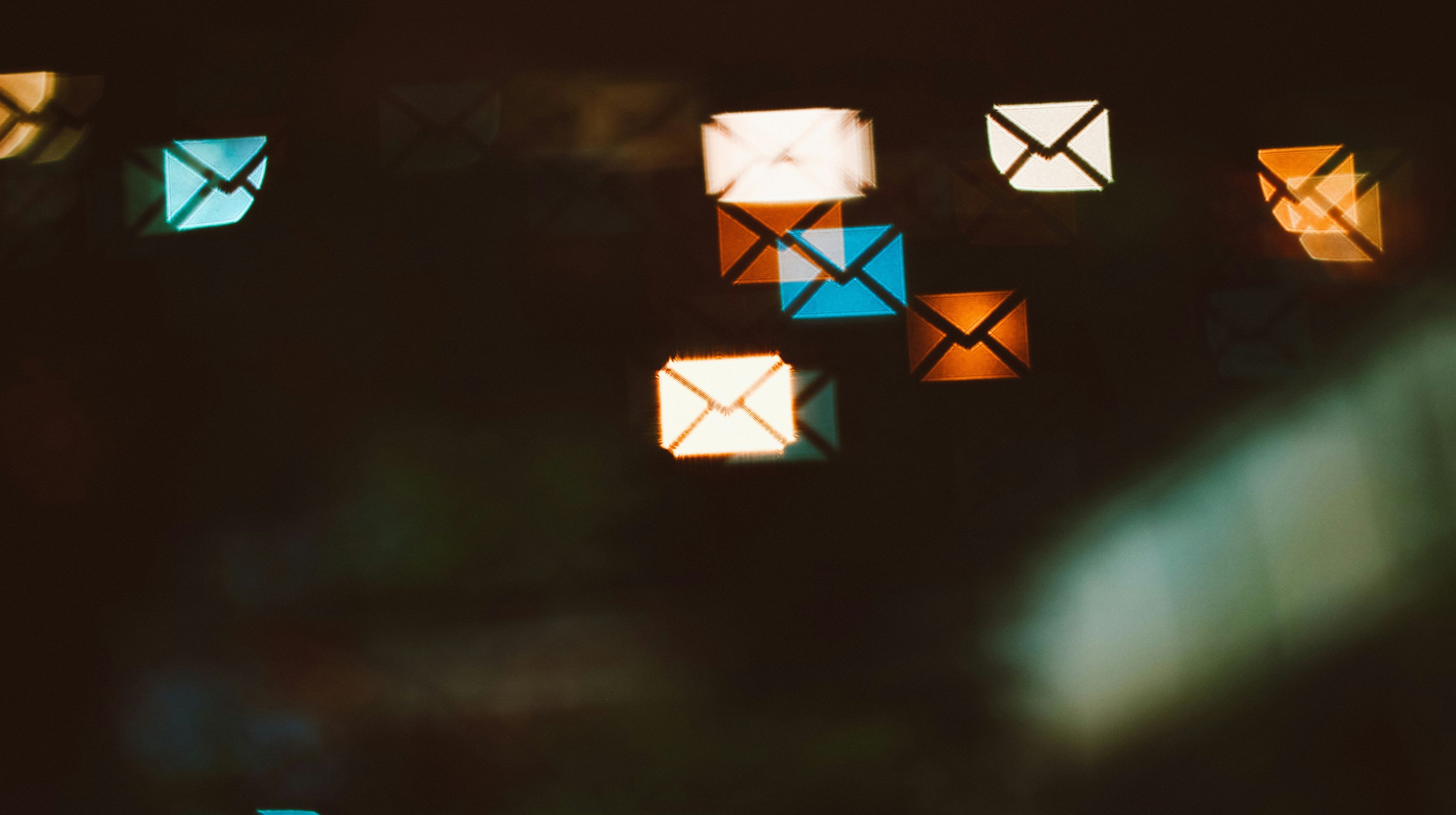 Titelbild des Blogbeitrags "DNS-Konfiguration von E-Mails". Zeigt verschiedene farbige Reflexionen von Briefumschlägen in einer Scheibe.