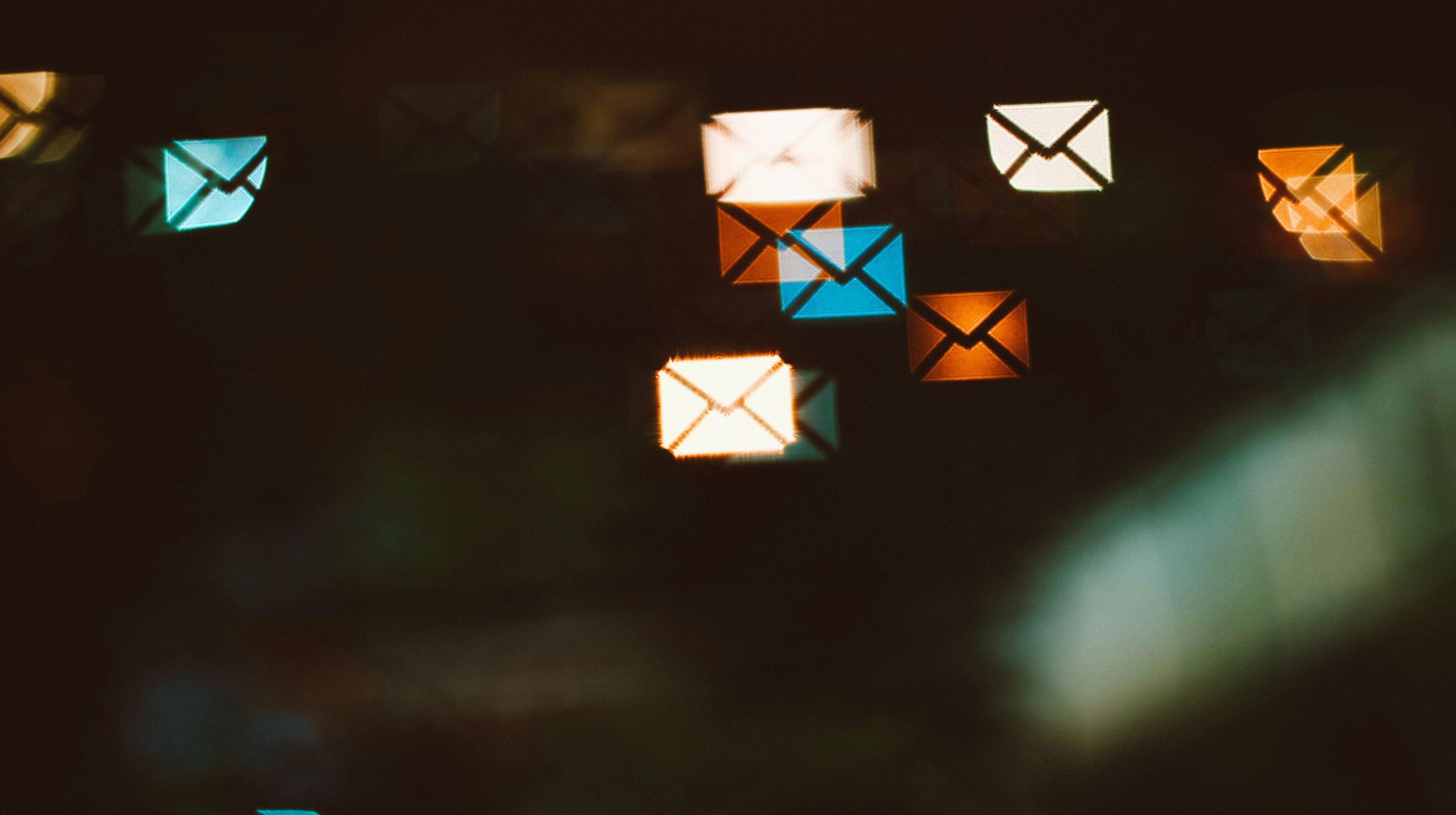 Titelbild des Blogbeitrags "DNS-Konfiguration von E-Mails". Zeigt verschiedene farbige Reflexionen von Briefumschlägen in einer Scheibe.