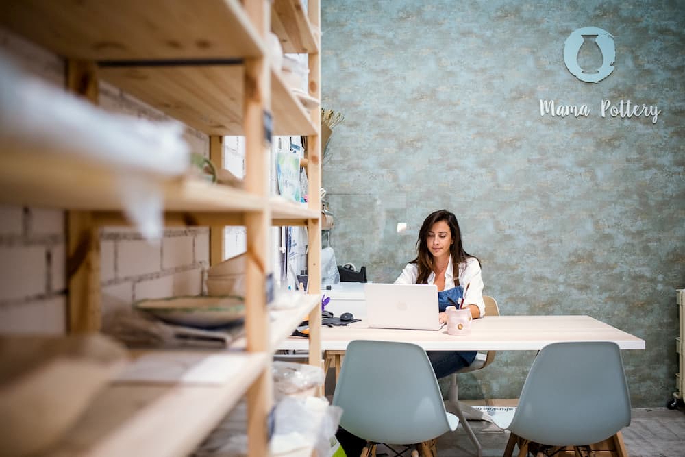 Imagen de Marina García sentada en su mesa de trabajo en Mama Pottery