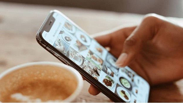 Person scrolling through their phone in a cafe