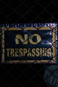 No Trespassing Sign on Black Wire Fence