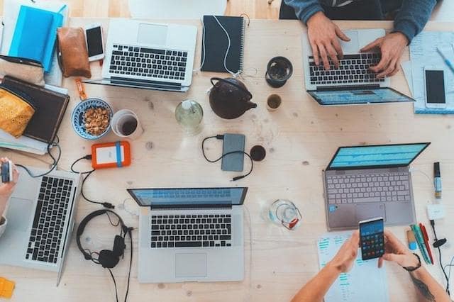 Overhead view of people working on laptops