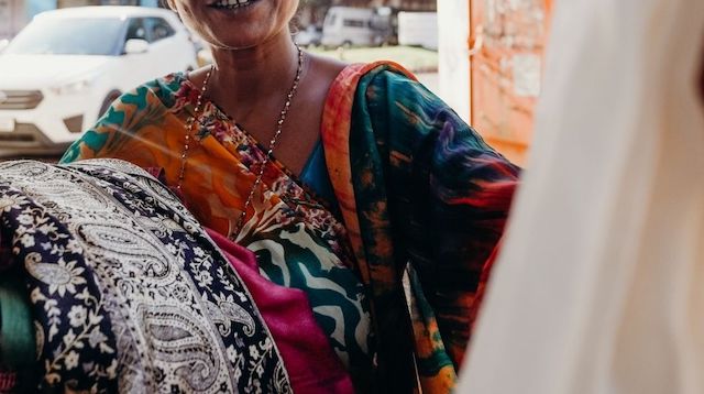 Woman Holding a Pile of Folded Fabric