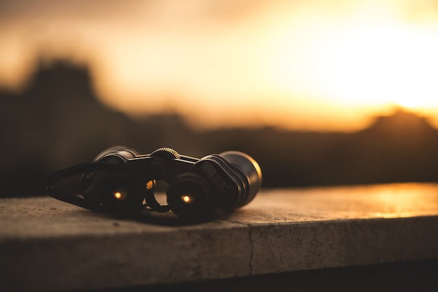 Binoculars sitting on ledge during sunset