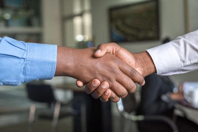 A firm handshake with a blurred background