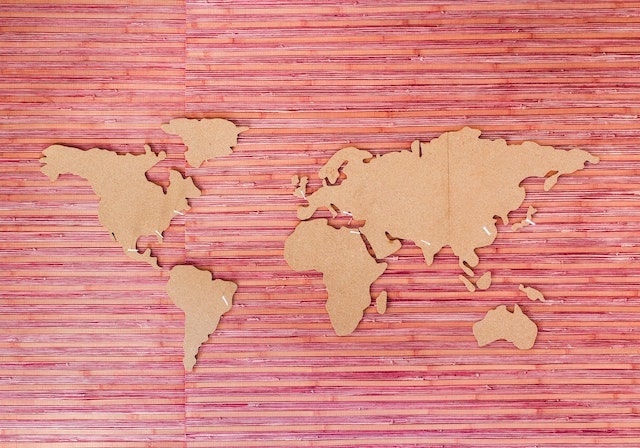 Cardboard cutouts of world map on pink background