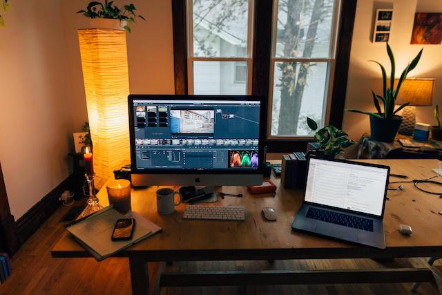 Home office with desktop computer showing video editing software