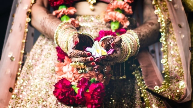 Indian bride holding a flower in her cupped hands